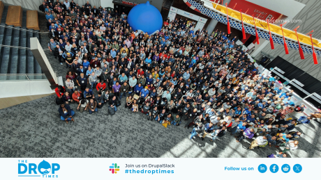 Group photo from DrupalCon Portland 2024 where attendees gather in the corridor and a giant Drupal Icon ballon is seen in the backdrop
