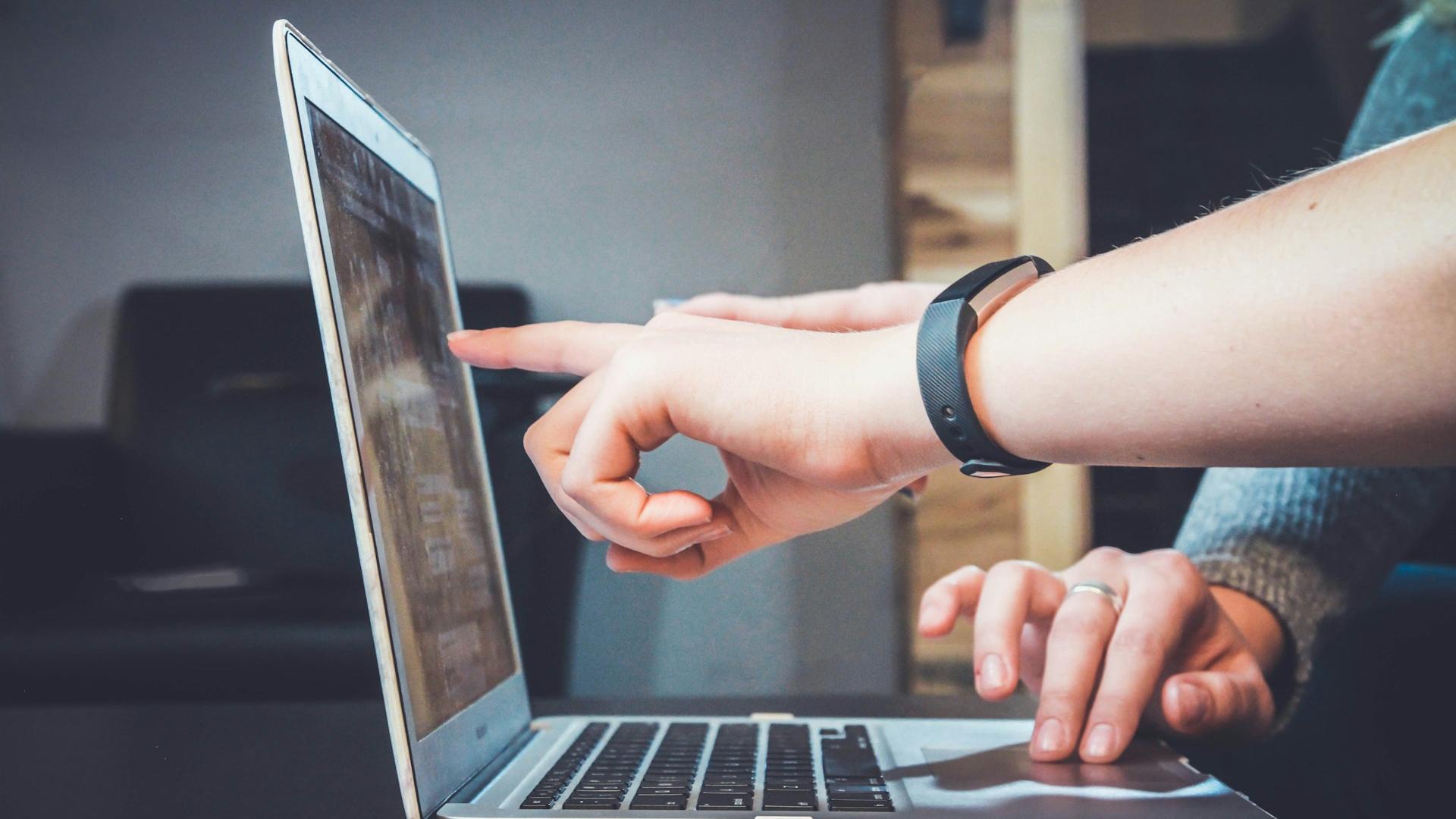 Man pointing to laptop screen